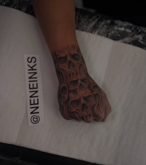 Detailed repeating skull tattoo across a hand